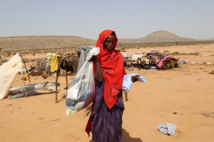Photo: A woman affected by cyclone Sagar in Lughaya District, Somaliland, holds some of the items she has received. World Vision emergency response team distributed hygiene kits, shoes, and clothes to families affected in Somaliland. World Vision's work in Somaliland was recently profiled in Relevant magazine. ©2018 World Vision, Adbirahman Abdilahi Muse.