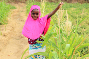 "The cornstalk and I are almost the same size!," says 8-year-old Ramatou in Niger. ©2018 World Vision